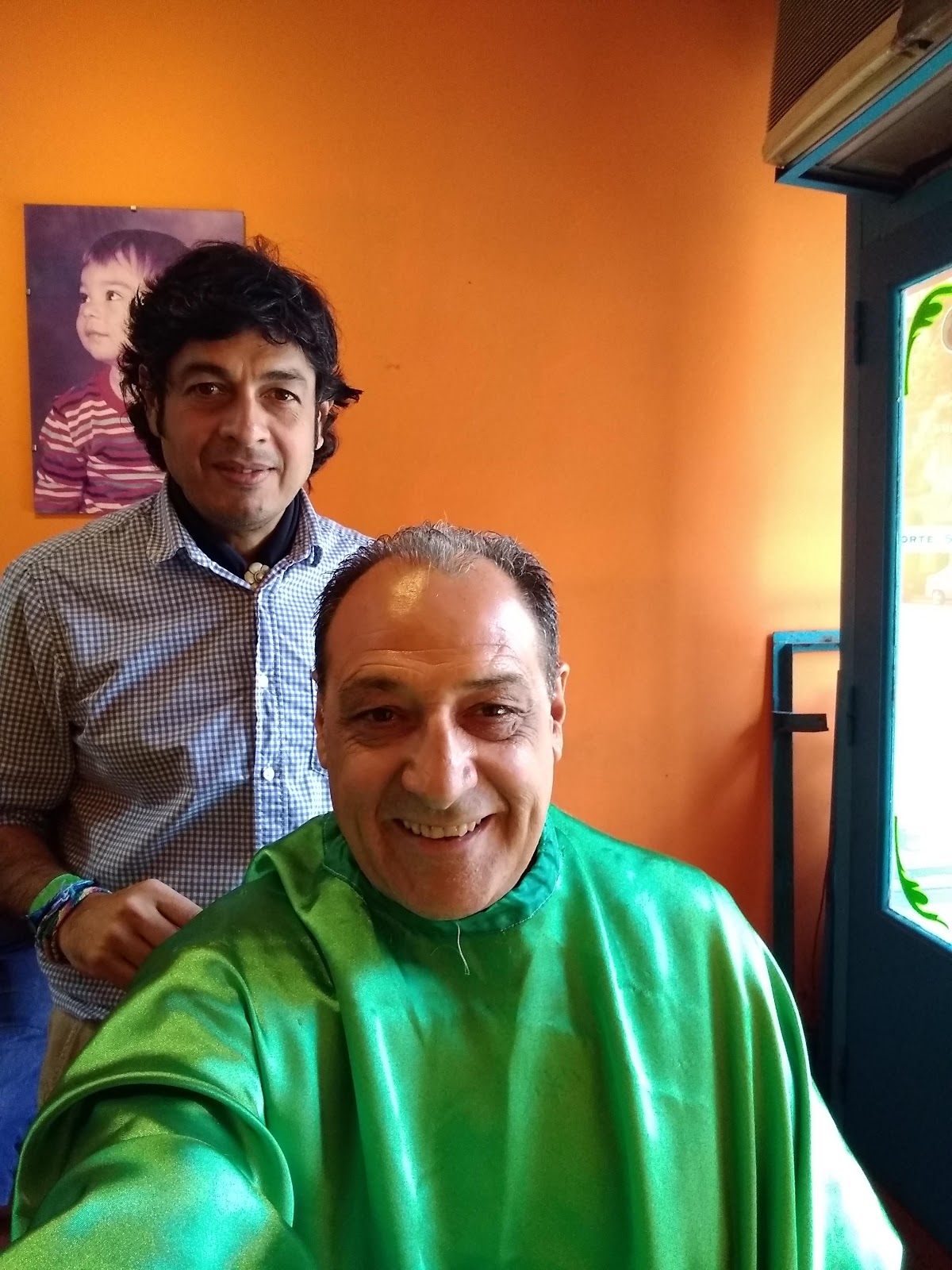 Cliente sonriente con Mateo después del corte