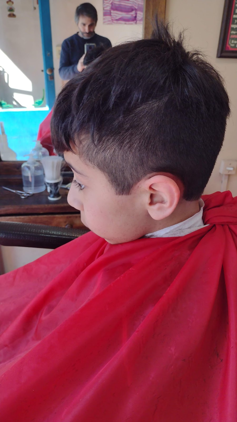 Corte de pelo terminado de un nene en la peluquería