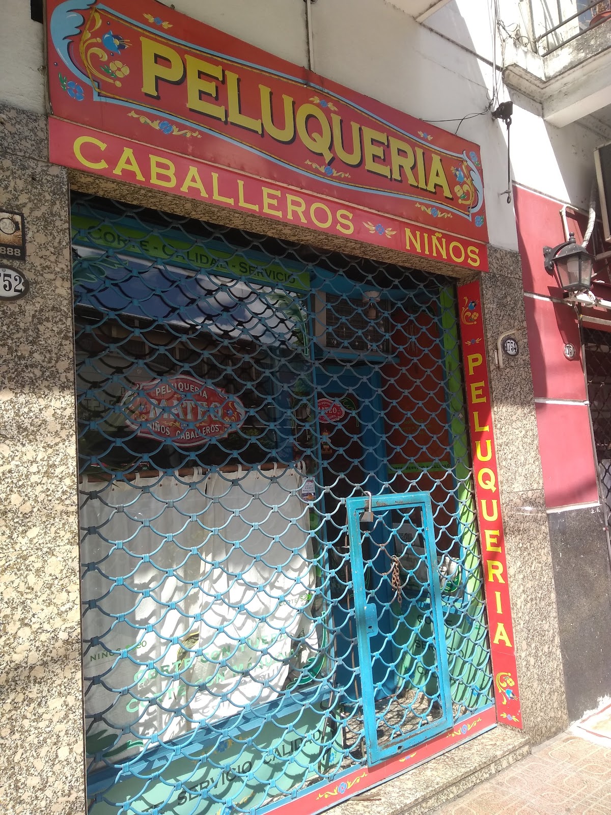 Fachada de Peluquería Mateo sobre Av. Independencia, con su cartel rojo de caballeros y niños